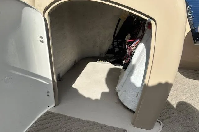 Slide: The Image of Open storage compartment on 2014 Manitou 24 Oasis SR boat, showing interior space and wiring. - 15