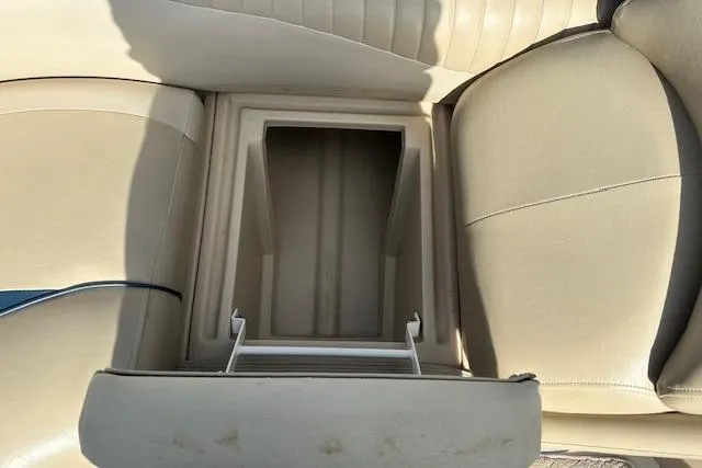 Slide: The Image of 2014 Manitou 24 Oasis SR boat seat storage compartment, beige upholstery. - 18