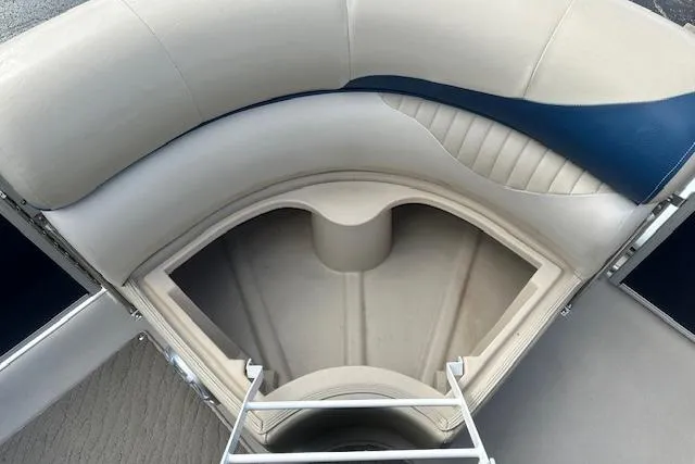 Slide: The Image of Interior seating of 2014 Manitou 24 Oasis SR pontoon boat, featuring storage compartment. - 20