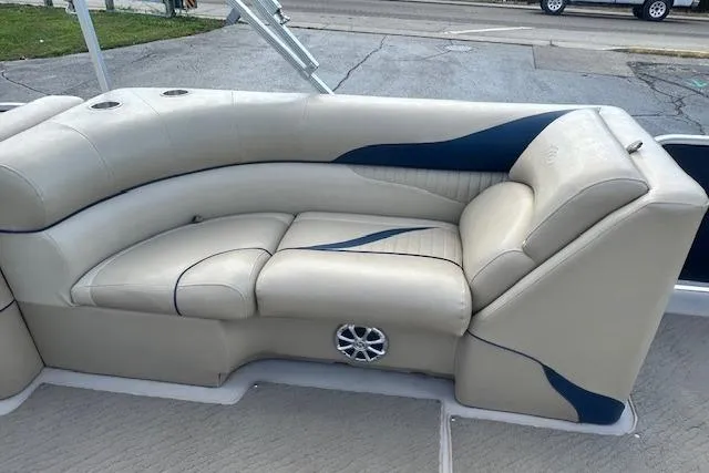 Slide: The Image of 2014 Manitou 24 Oasis SR boat interior with beige and blue seating. - 22