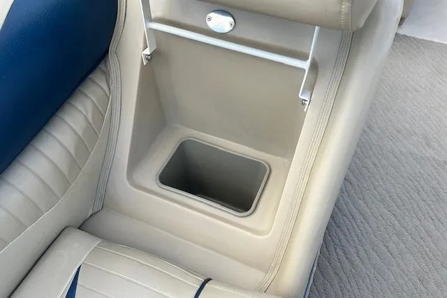 Slide: The Image of 2014 Manitou 24 Oasis SR boat interior with beige and blue seating and storage compartment. - 23