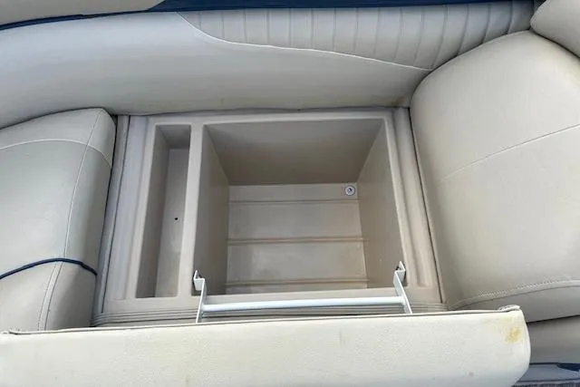 Slide: The Image of 2014 Manitou 24 Oasis SR boat seat storage compartment, open and empty. - 24