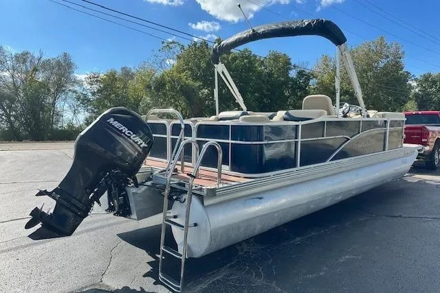 Slide: The Image of 2014 Manitou 24 Oasis SR pontoon boat with Mercury outboard motor, parked outdoors. - 3