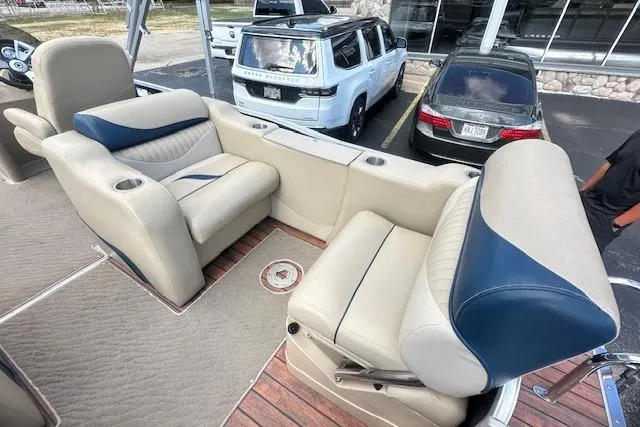 Slide: The Image of 2014 Manitou 24 Oasis SR boat interior with beige and blue seating. - 7