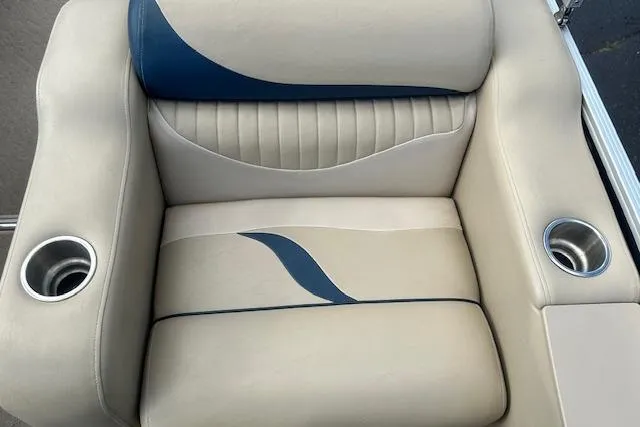 Slide: The Image of 2014 Manitou 24 Oasis SR boat seat with cup holders, beige and blue design. - 9