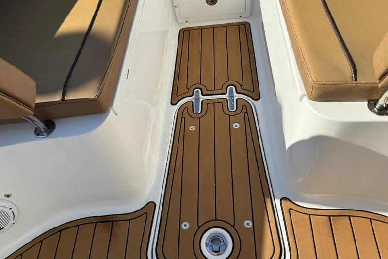 Slide: The Image of 2022 Sea Hunt Ultra 275 SE boat interior with teak flooring and cushioned seating. - 17