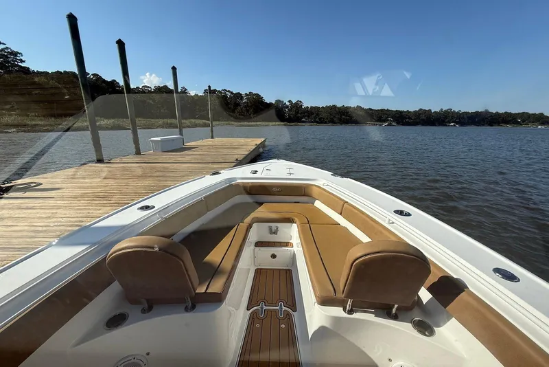 Slide: The Image of 2022 Sea Hunt Ultra 275 SE boat docked on a serene lake. - 18