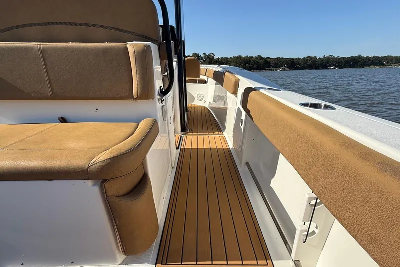 Slide: The Image of 2022 Sea Hunt Ultra 275 SE boat interior with tan seating and wood-style flooring. - 20