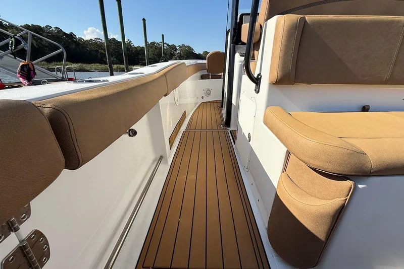 Slide: The Image of 2022 Sea Hunt Ultra 275 SE boat interior with tan seating and wooden flooring. - 21