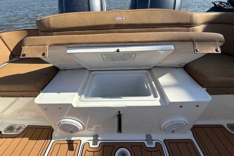Slide: The Image of 2022 Sea Hunt Ultra 275 SE boat with open storage compartment and cushioned seating. - 25