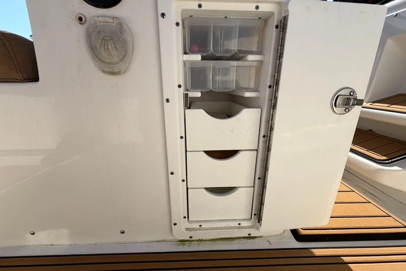 Slide: The Image of 2022 Sea Hunt Ultra 275 SE storage compartment with drawers and tackle boxes. - 29