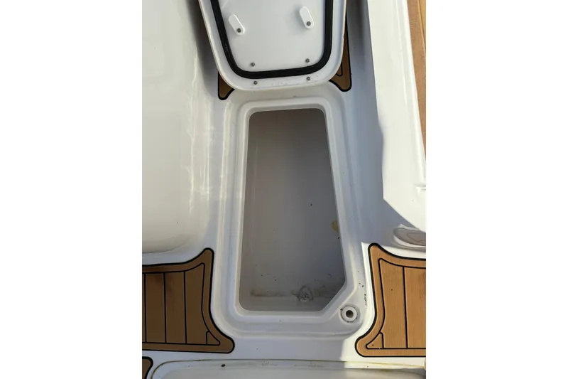 Slide: The Image of Storage compartment on a 2022 Sea Hunt Ultra 275 SE boat, featuring teak-style flooring. - 30