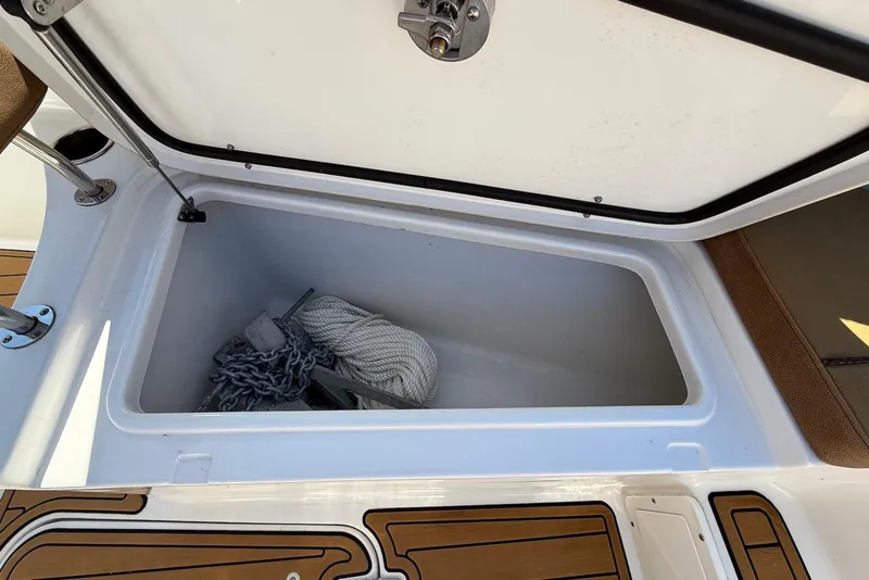 Slide: The Image of Open storage compartment on 2022 Sea Hunt Ultra 275 SE boat with anchor and rope. - 32