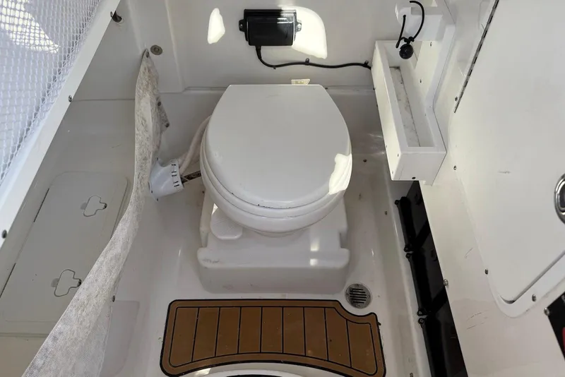 Slide: The Image of 2022 Sea Hunt Ultra 275 SE boat interior with marine toilet and storage compartments. - 33
