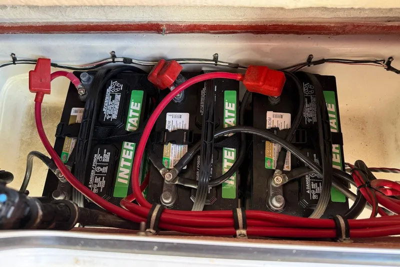 Slide: The Image of Batteries in a 2022 Sea Hunt Ultra 275 SE boat, featuring Interstate branding and red cables. - 36