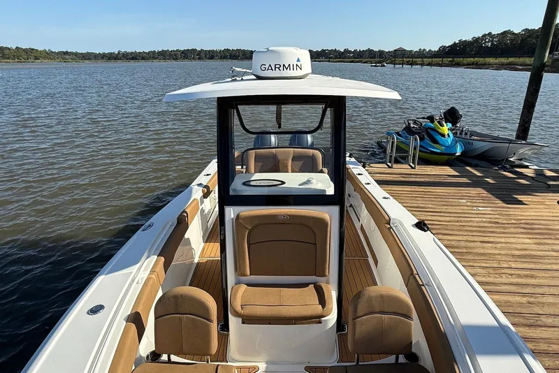 Slide: The Image of 2022 Sea Hunt Ultra 275 SE boat docked by a lake with Garmin equipment. - 4