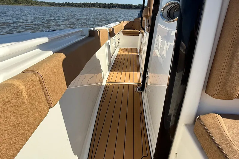 Slide: The Image of 2022 Sea Hunt Ultra 275 SE boat interior with cushioned seating and wood-style flooring. - 6