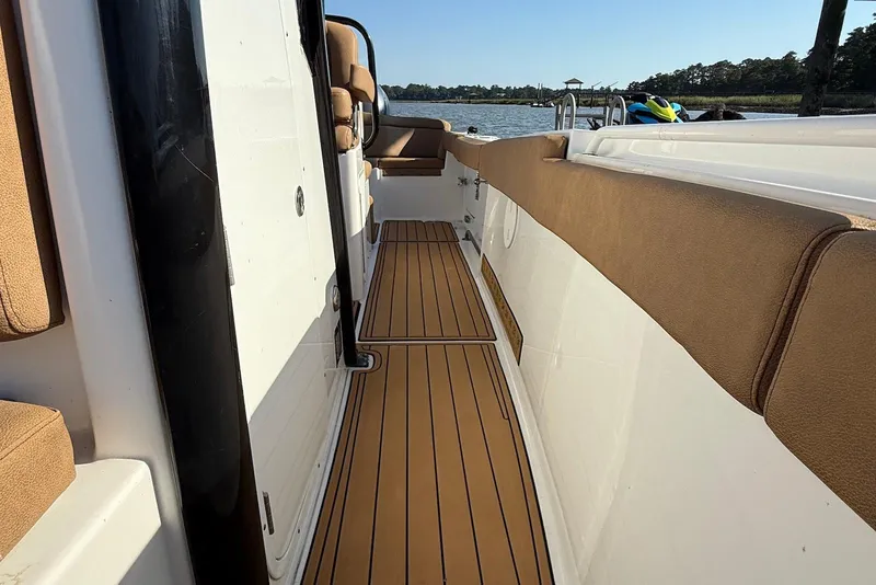 Slide: The Image of 2022 Sea Hunt Ultra 275 SE boat interior with tan seating and wooden flooring. - 7