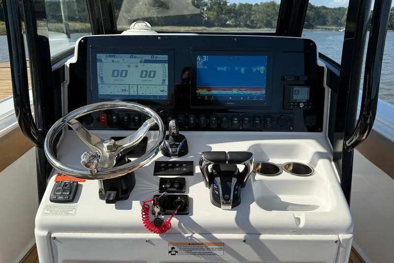 Slide: The Image of Control panel of 2022 Sea Hunt Ultra 275 SE boat with steering wheel and digital displays. - 9