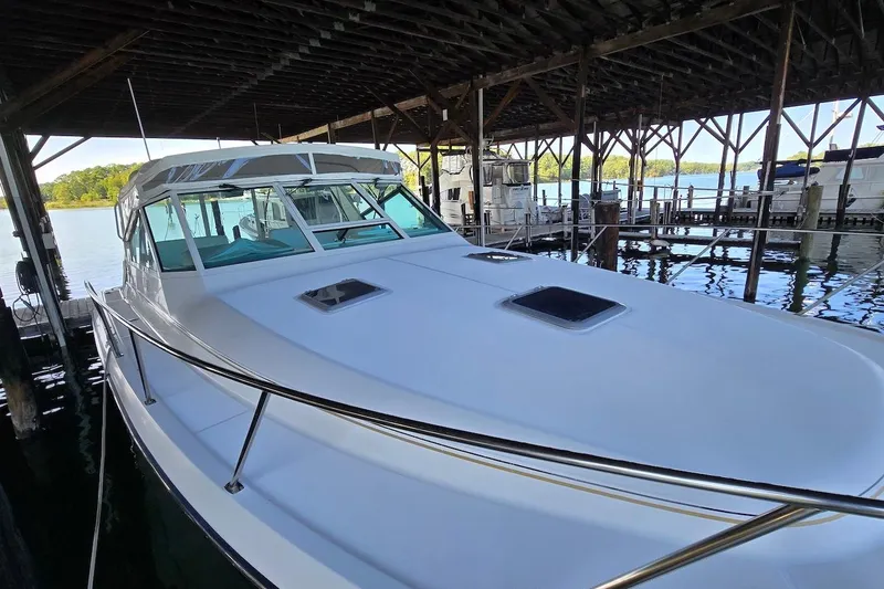 Slide: The Image of 1996 Tiara Yachts 3700 Open docked, featuring covered cockpit and Garmin equipment. - 18