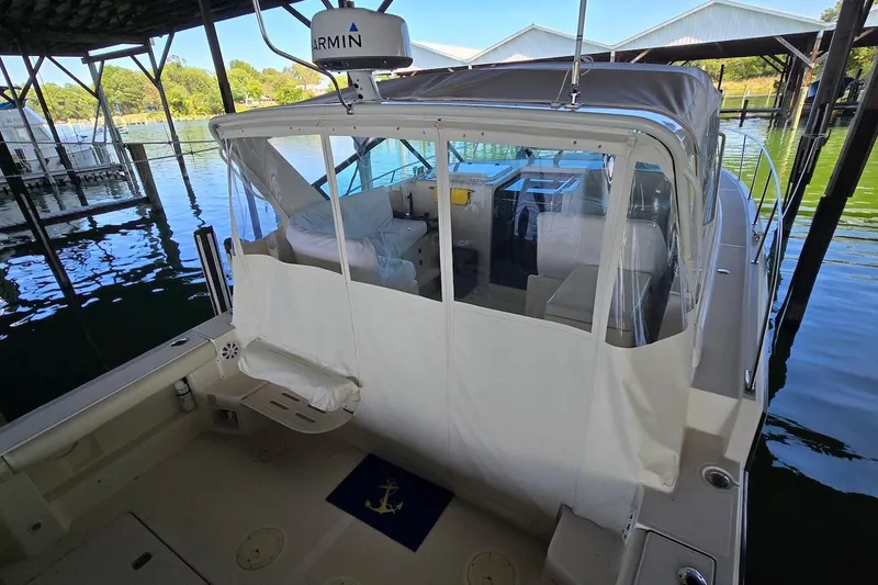 Slide: The Image of 1996 Tiara Yachts 3700 Open docked under a covered marina with scenic water view. - 21