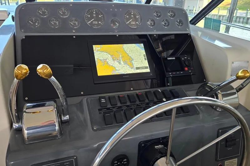 Slide: The Image of 1996 Tiara Yachts 3700 Open docked under a covered marina, showcasing sleek design. - 25