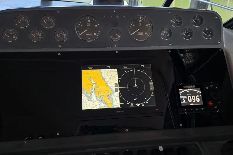 Slide: The Image of 1996 Tiara Yachts 3700 Open docked, featuring covered seating and Garmin equipment. - 26