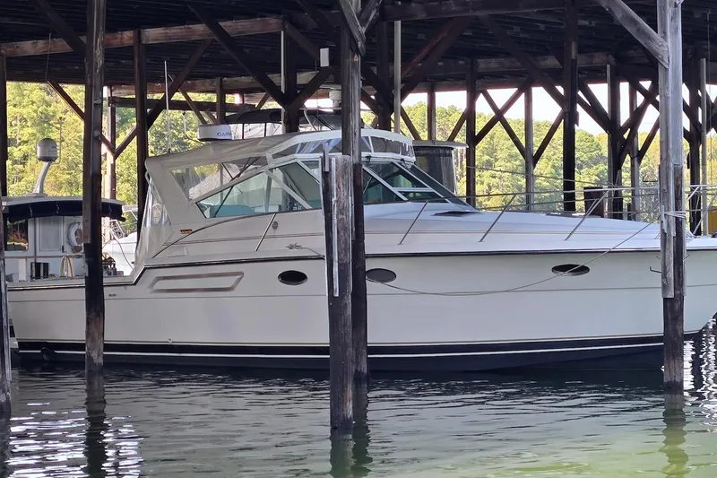 Slide: The Image of 1996 Tiara Yachts 3700 Open docked under a wooden shelter. - 7
