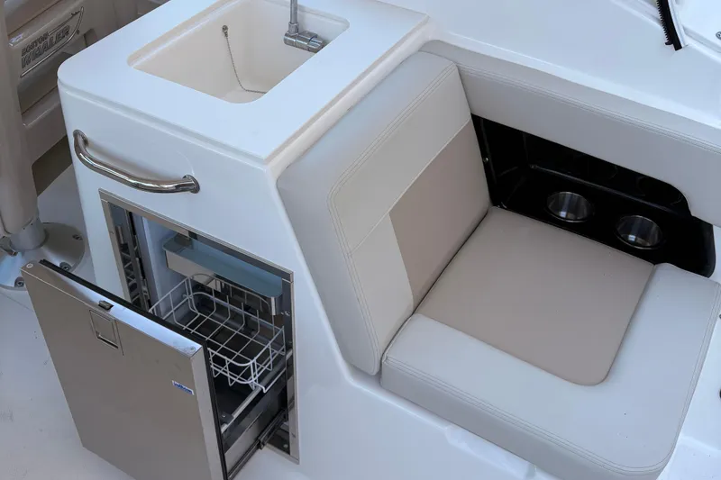 Slide: The Image of 2025 Boston Whaler 280 Vantage boat interior with illuminated dashboard and seating. - 9