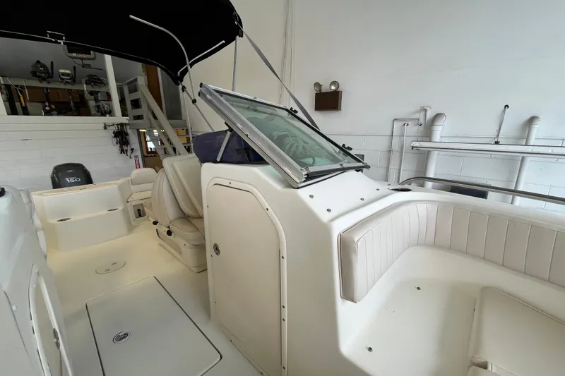 Slide: The Image of 2006 Hydra-Sports Lightning 202 DC boat interior with seating and windshield in a garage. - 10