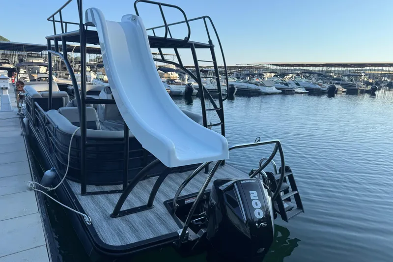 Slide: The Image of 2025 Bennington 26 L Top Deck pontoon boat with slide, docked at marina. - 10