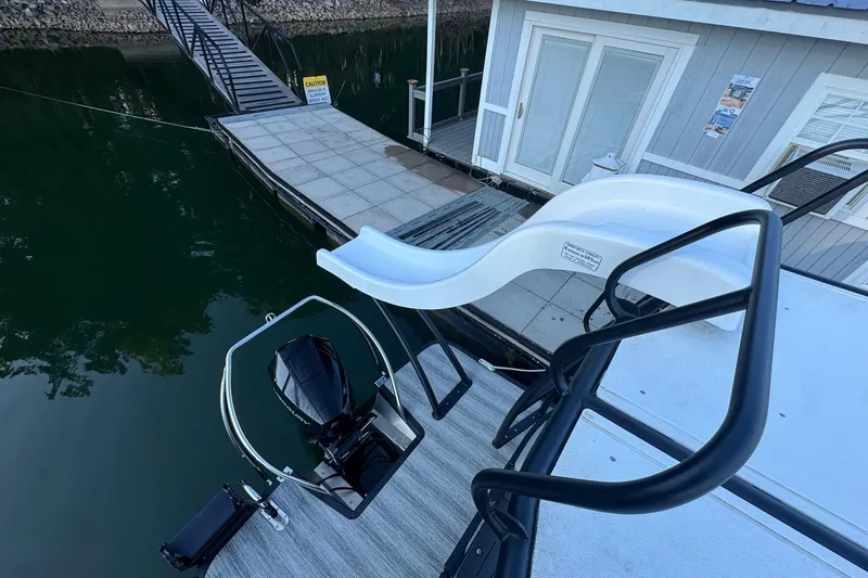 Slide: The Image of 2025 Bennington 26 L Top Deck pontoon boat with slide, docked at marina. - 8