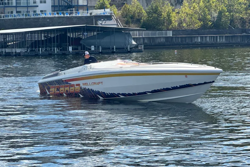 The Image of 1995 Excel Scarab 43 speedboat on water near dock, vibrant graphics, sunny day. - 1