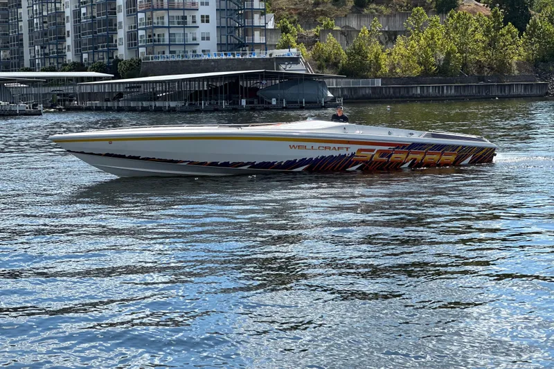 Slide: The Image of 1995 Excel Scarab 43 speedboat on water near modern buildings. - 13