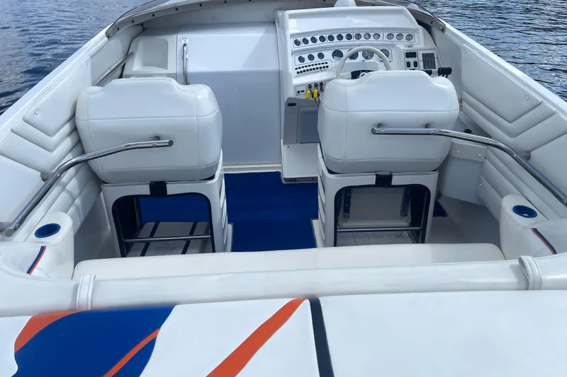 Slide: The Image of 1995 Excel Scarab 43 boat interior with white seating and blue accents on water. - 16