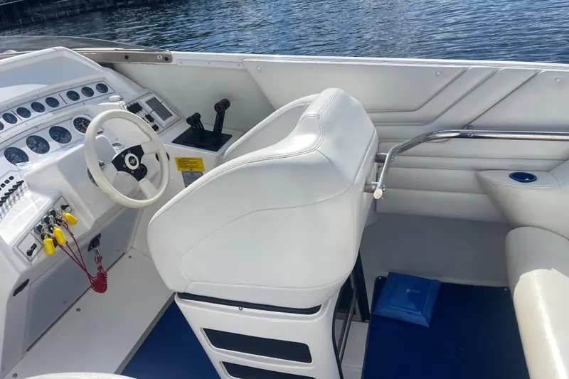 Slide: The Image of Interior of a 1995 Excel Scarab 43 boat with white seating and control panel. - 18