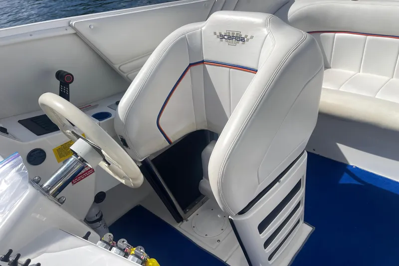 Slide: The Image of 1995 Excel Scarab 43 boat interior with white seating and steering wheel. - 22