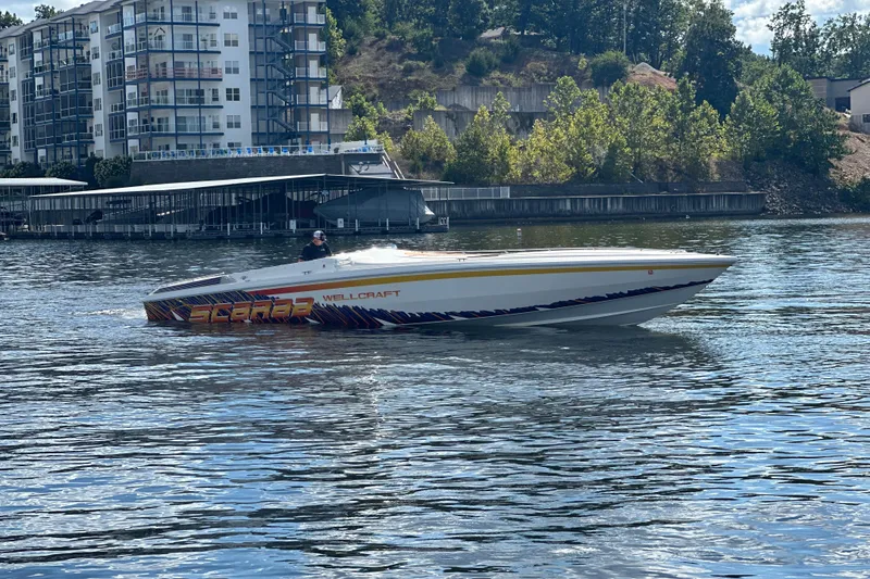 Slide: The Image of 1995 Excel Scarab 43 boat cruising on a river near modern apartments. - 6