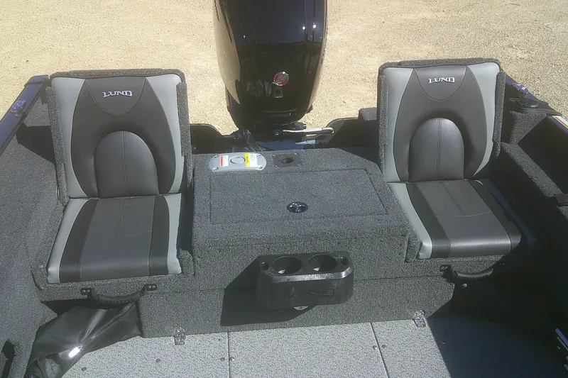 Slide: The Image of 2026 Lund 1775 Adventure Sport boat interior with two cushioned seats and motor. - 11