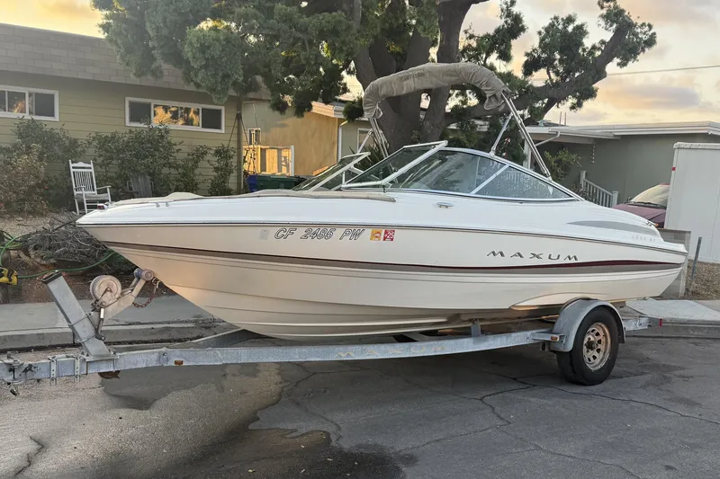 The Image of 2002 Maxum 1900 SR boat on trailer, parked in residential area. - 0