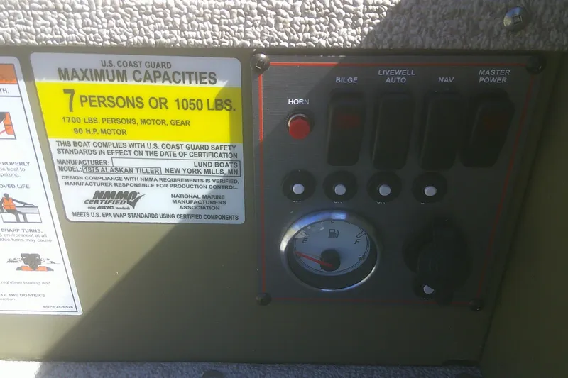 Slide: The Image of Control panel of 2026 Lund 1875 Alaskan Tiller boat with capacity and safety labels. - 10