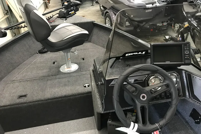 Slide: The Image of 2026 Lund 1650 Rebel XL SS boat interior with steering wheel and seating. - 12