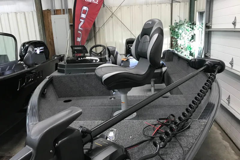 Slide: The Image of 2026 Lund 1650 Rebel XL SS boat interior with seating and equipment in a garage. - 6