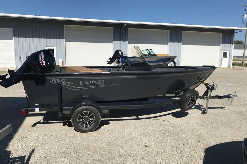 Slide: The Image of 2026 Lund 1650 Rebel XL SS boat interior with gray seating and storage compartments. - 8