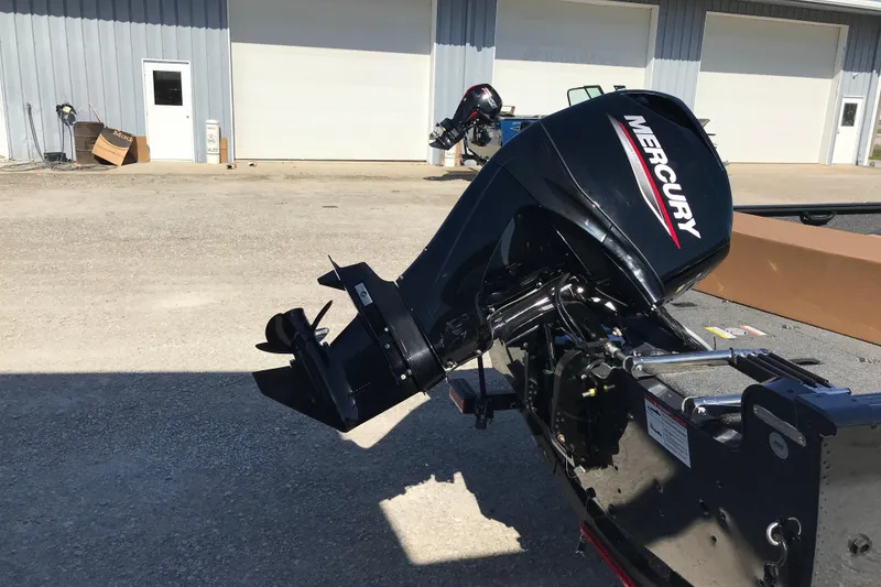 Slide: The Image of 2026 Lund 1650 Rebel XL SS boat interior with storage compartments and motor. - 9