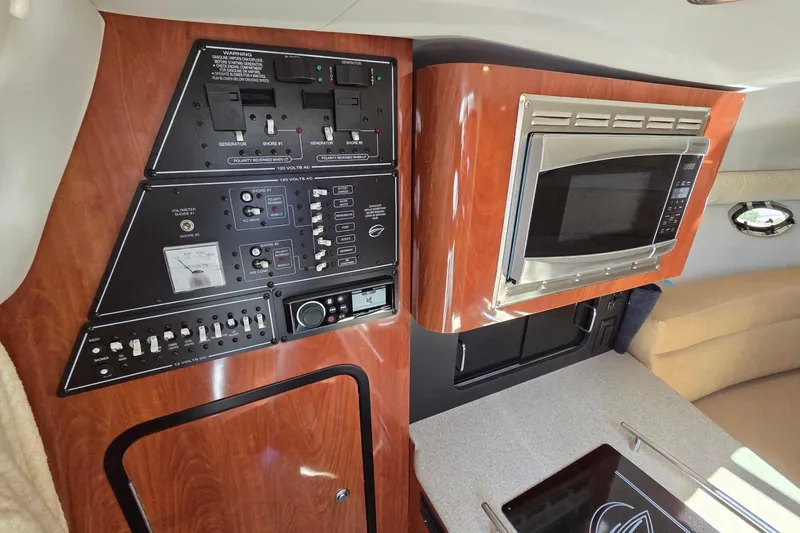 Slide: The Image of Control panel and microwave in 2013 Crownline 325 SCR boat interior. - 19