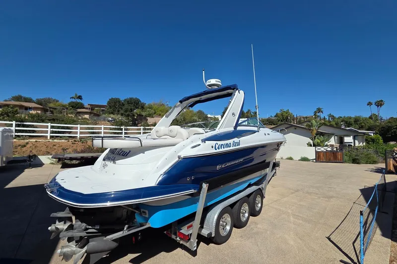 Slide: The Image of 2013 Crownline 325 SCR boat on trailer in sunny residential area. - 2