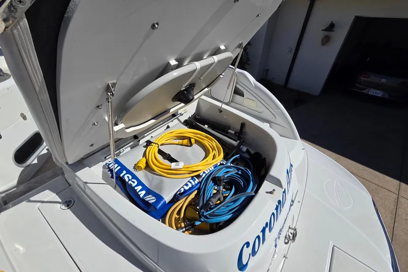 Slide: The Image of Open storage compartment on 2013 Crownline 325 SCR boat with cables and equipment. - 24