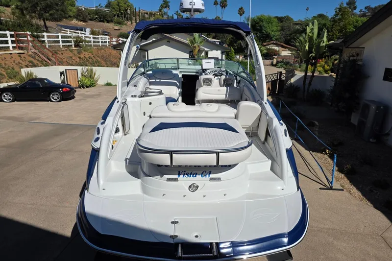 Slide: The Image of 2013 Crownline 325 SCR boat with spacious deck and seating, parked outdoors. - 3