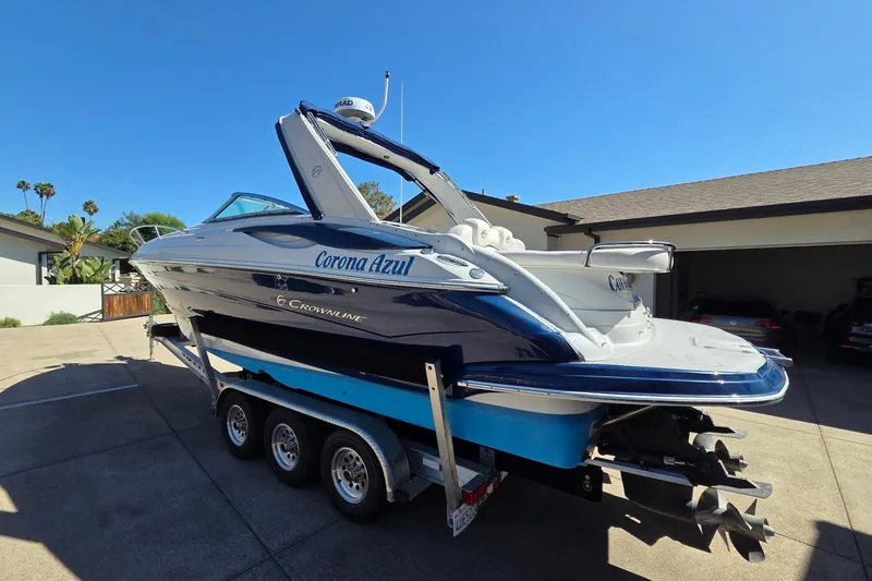 Slide: The Image of 2013 Crownline 325 SCR boat on trailer in driveway under clear blue sky. - 4